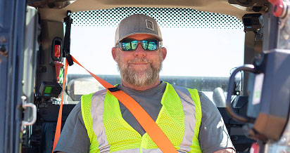 Man in work gear wearing reflective vest and sunglasses